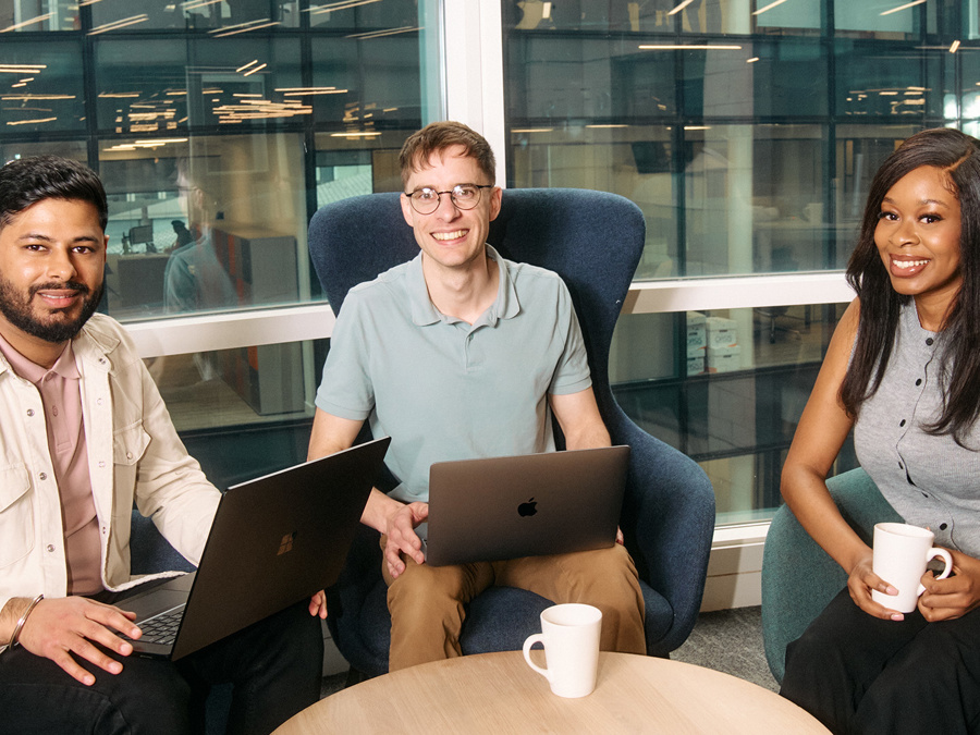 a group of people sitting in chairs with laptops