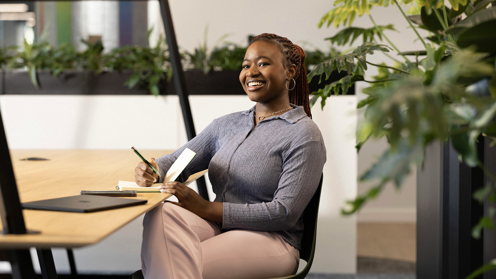a person sitting at a desk holding a pen and notepad