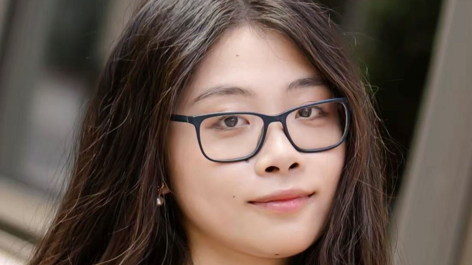 a person wearing glasses and a graduation gown